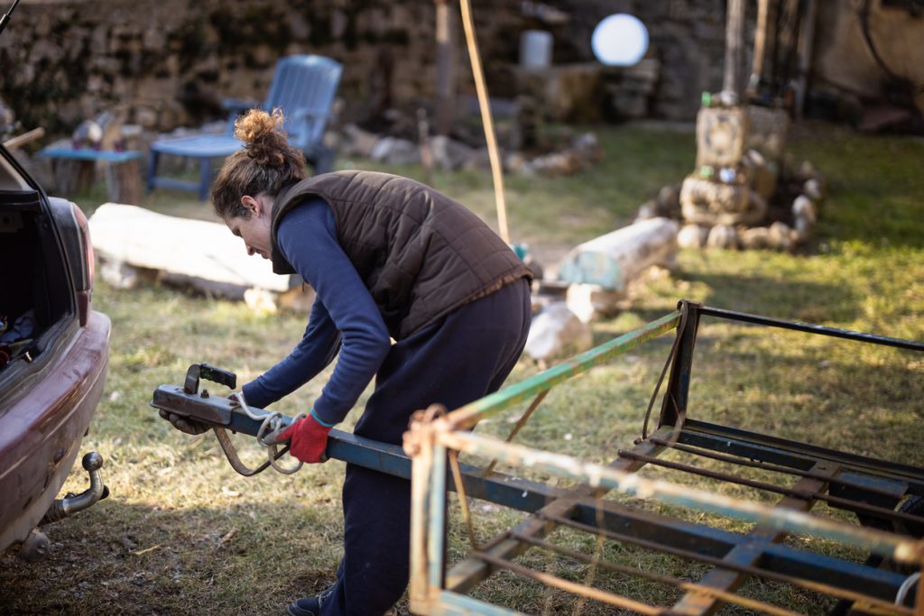 Mid Adult Woman Attaching Trailer on Car - Stock Photo