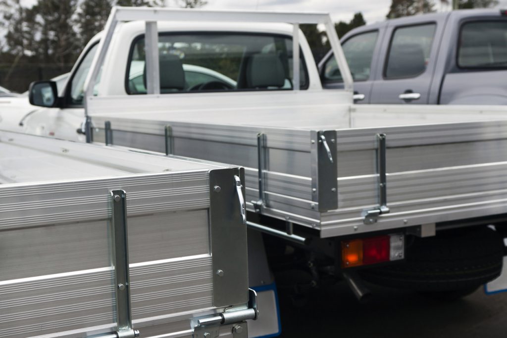 service body truck beds - Closeup rear view of small white trucks - ute, full frame vertical composition
