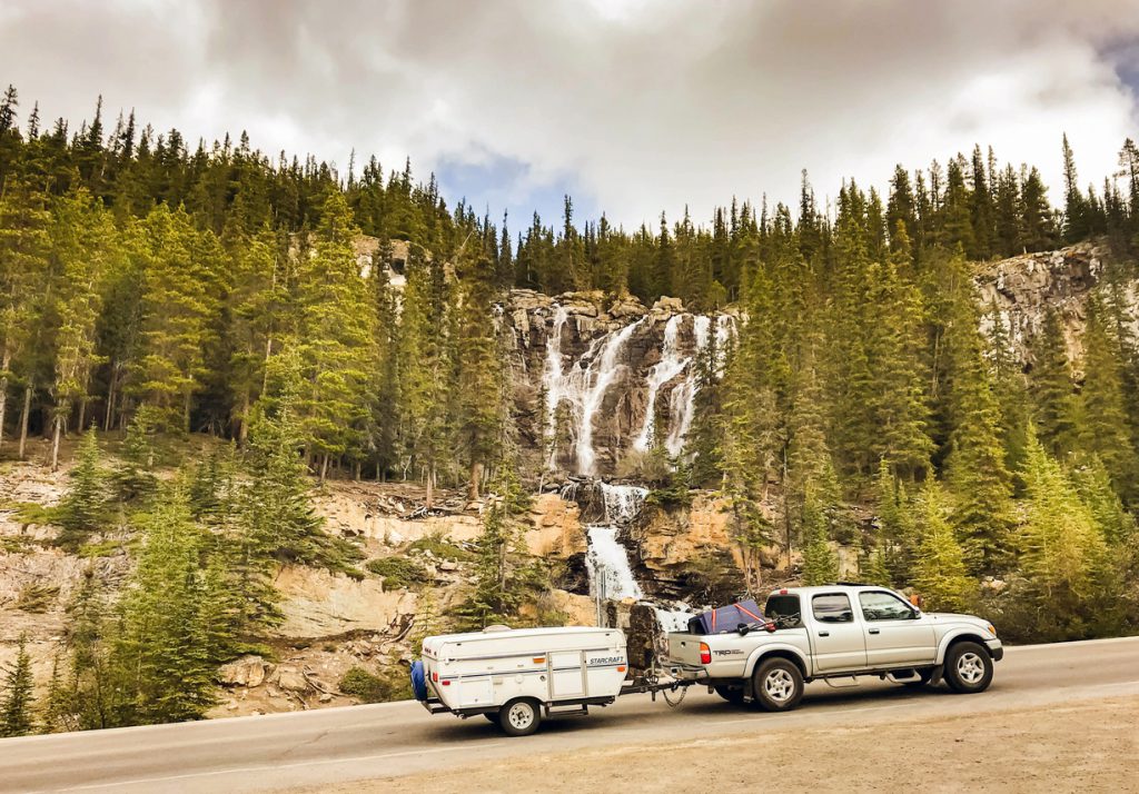 Columbia Icefield, Alberta, canada - June 2018: Truck pulling a camping trailer on a scenic road through the Columbia Icefield in Alberta, Canada.