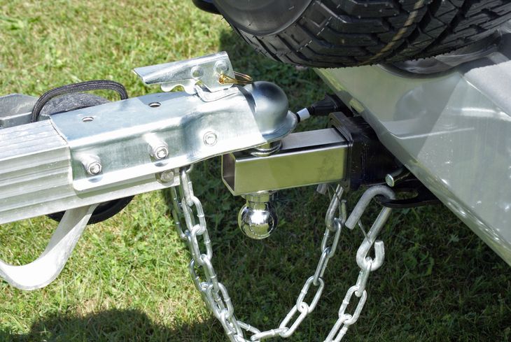 Close up of a ball hitch connection between a trailer and a car.