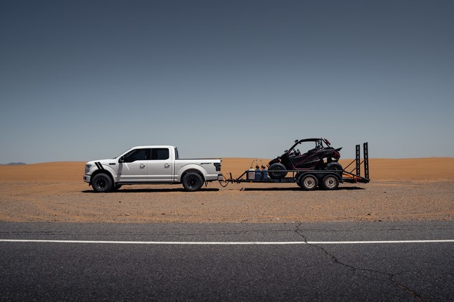 A truck with a UTV in the trailer. 