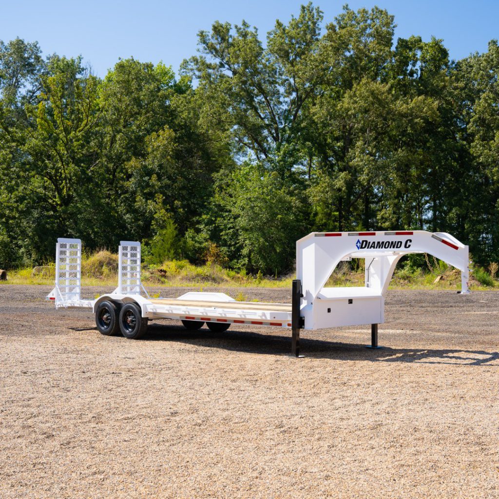 White Diamond C gooseneck trailer parked outside.