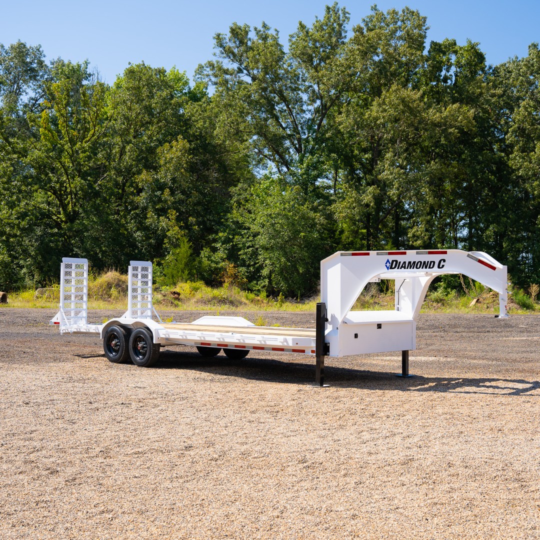 White Diamond C gooseneck trailer parked outside.