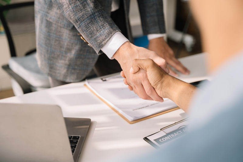 Close up two men shake hands at office negotiations. 