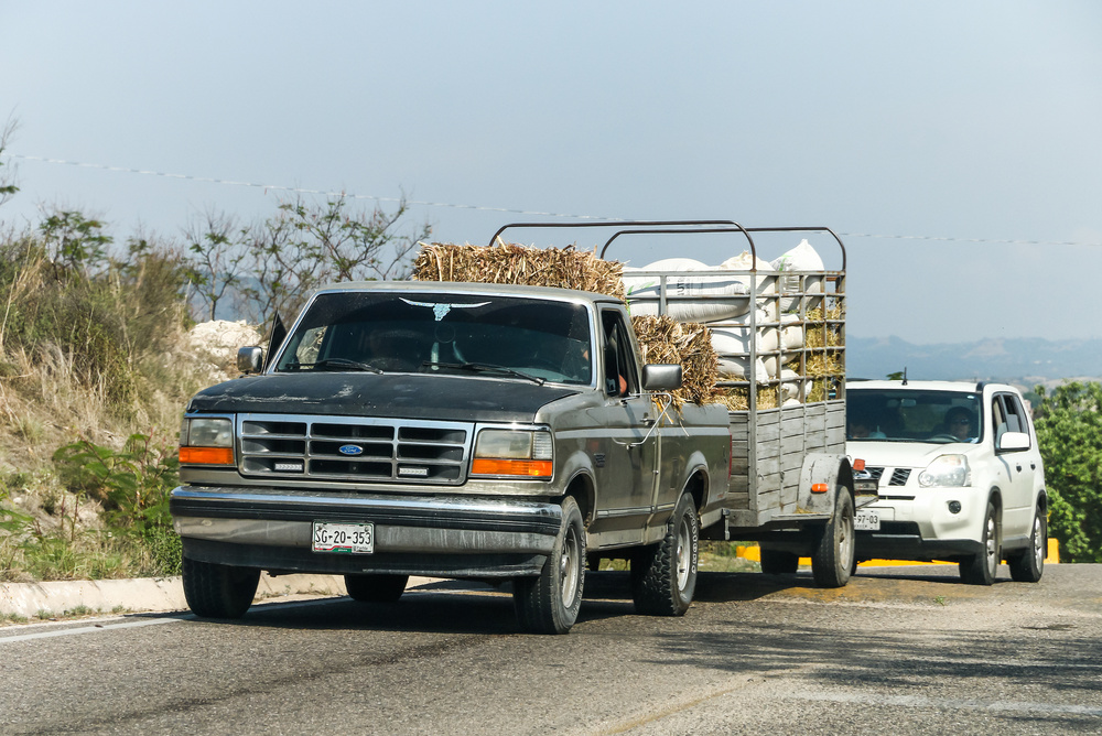 A trailer hitched to a pickup truck after the driver finishes buying a used trailer.