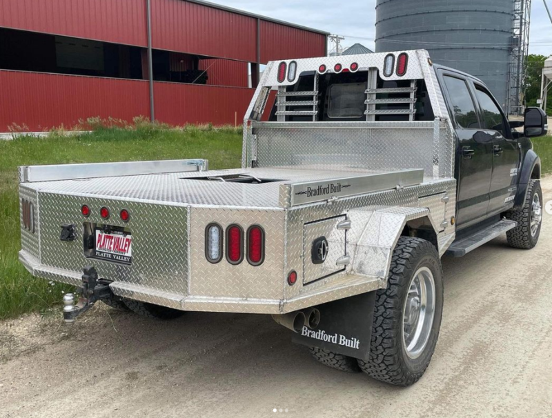 An aluminum step side Bradford Built flatbed on a truck. 