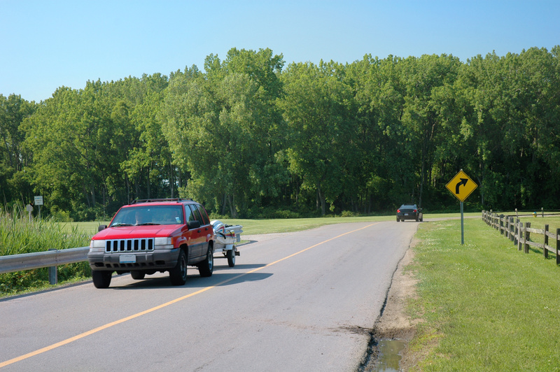 Sport utility vehicle towing a small jet ski trailer in a Michigan, USA.