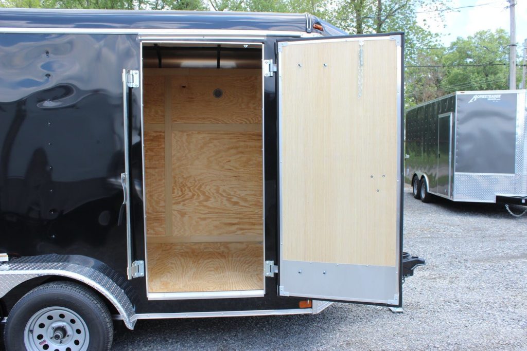 Trailer Side Door A black cargo trailer with an open side access door, an essential consideration when it comes to how to choose a trailer.