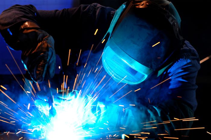 Trailer Welder Professional trailer repair service. Man welds a trailer during a repair.