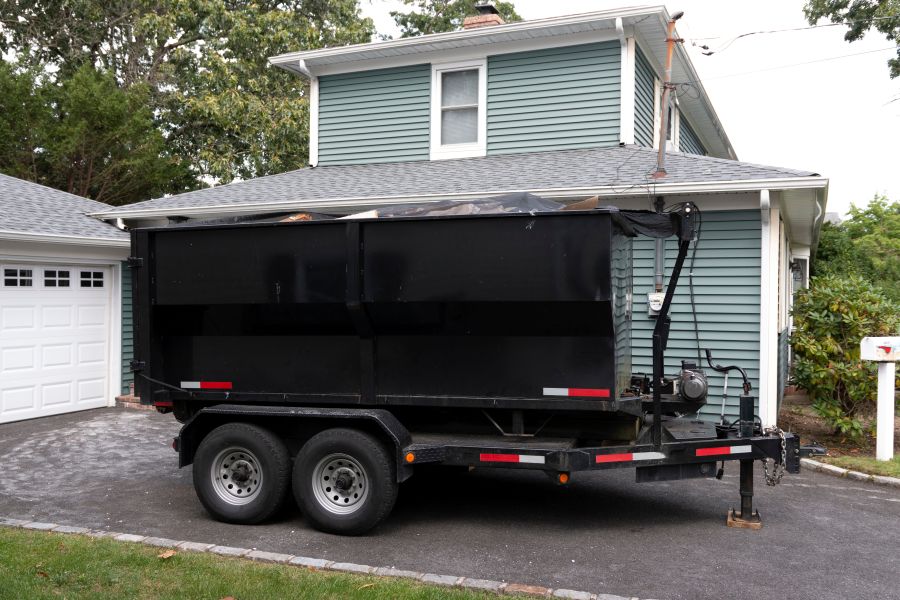 Dumpster on a trailer in a residential driveway